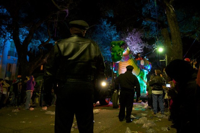 Policemen keep the crowds off of the parade route to make way for the annual Bacchusaurus float from the Krewe of Bacchus during their annual meander through Uptown.  Streets become littered with uncaught beads and empty plastic sacks that held precious clutches of beads.  At these parades you could almost stand still on the sidelines and still get covered in beads without much effort at all.  Showing skin is certainly taboo during these family affairs.  Children sit in makeshift benches affixed to the tops of ladders that families roll down to the parade route to establish a good spot to be able to collect beads.  "Throw me something, mister!" is the call. 