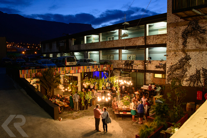 Dinner party scene in the Woodstock neighborhood of Cape Town with Table Mountain in background.