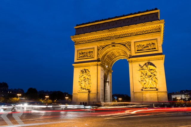 The Arc de Triomphe at dusk in the Place Charles de Gaulle in Paris, France.