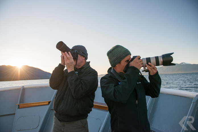 Two photographers on the bow of a ship.